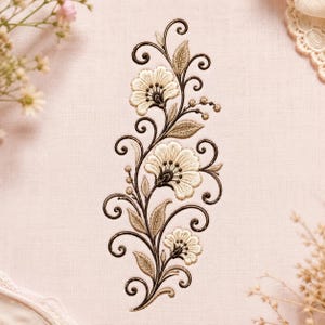 May include: An embroidery design featuring three cream-colored flowers with dark brown outlines and intricate swirling stems. The floral pattern includes detailed leaves and small buds, all stitched onto a light pink fabric background.