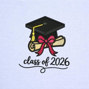 May include: Embroidered graduation design featuring a black mortarboard with a gold tassel, a rolled diploma tied with a red bow, and the text "class of 2026" in a script font. The design is on a white background.