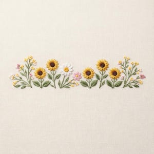 May include: Embroidered floral design featuring sunflowers, daisies, and other wildflowers in yellow, white, and pink. The flowers have brown centers and green leaves, arranged in a horizontal row on a cream-colored fabric.