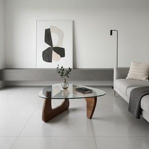 Könnte beinhalten: Ein modernes Wohnzimmer mit einem Couchtisch mit Glasplatte und Holzfuß. Das graue Sofa hat eine Decke und ein Kissen. Ein abstraktes Kunstwerk hängt an der Wand. Eine schwarze Stehlampe steht neben dem Sofa. Der Tisch ist 120 cm lang.