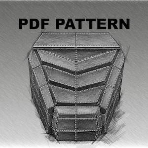 May include: A digital sketch of a geometric, multi-faceted object resembling a helmet or mask, rendered in shades of gray with visible rivet details along the edges. The text "PDF PATTERN" is printed in bold black letters above the object.