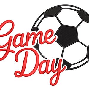 May include: A soccer ball graphic with black and white pentagons and hexagons. The words "Game Day" are written in red, cursive script, positioned to the left of the ball. The design is suitable for sports-themed products.
