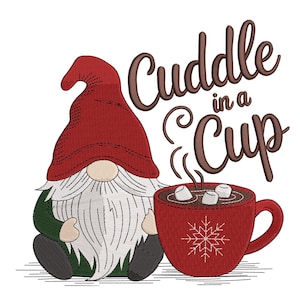 May include: An embroidered design featuring a gnome wearing a red hat and holding a red mug of hot chocolate with marshmallows. The text "Cuddle in a Cup" is written above the mug in brown script.