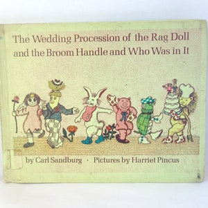 May include: A vintage children's book cover with a colorful illustration of a wedding procession of rag dolls and a broom handle. The title is "The Wedding Procession of the Rag Doll and the Broom Handle and Who Was in It" by Carl Sandburg, with illustrations by Harriet Pincus.