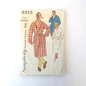 May include: Vintage Simplicity printed pattern 2312 for a large-sized robe. The pattern features illustrations of men's robes in various styles, including a red and white plaid robe, a blue robe, and a white robe. The pattern is marked "50c".