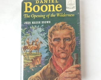 May include: A vintage hardcover book titled "Daniel Boone The Opening of the Wilderness" by John Mason Brown. The cover features a portrait of Daniel Boone and an illustration of Native Americans on horseback. The book has a green and yellow color scheme.