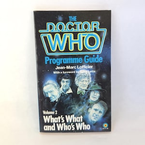 May include: A vintage "Doctor Who" Programme Guide, Volume 2, with the title in blue and yellow. The cover shows portraits of actors and the text "What's What and Who's Who". Published by Target Books.