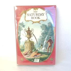 May include: The cover of a red book titled "The Saturday Book" with an illustration of a landscape with a gold urn, a man fishing, and a man on a bicycle.