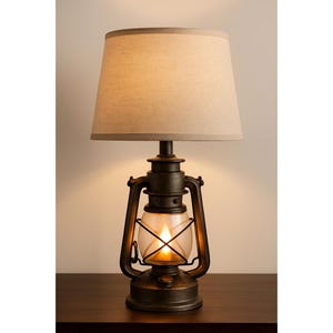 May include: A rustic-style table lamp with a lantern base and a beige lampshade. The lamp has a dark bronze finish and a clear glass enclosure around the light source. The lamp is approximately 24 inches tall.