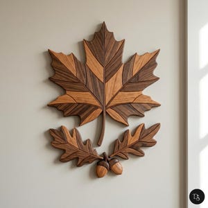 May include: A wooden wall art piece featuring a large maple leaf and a smaller oak leaf arrangement with acorns. The leaves are crafted from various shades of brown wood, creating a striking contrast. The artwork is mounted on a neutral-colored wall.