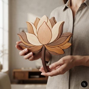 Pode incluir: Uma escultura decorativa de madeira em forma de flor de lótus, feita com vários tons de madeira natural, apresentando pétalas em camadas em tons de castanho claro, médio e escuro. A peça inclui um caule de madeira curvo na base.