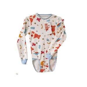 May include: White long-sleeved bodysuit featuring a pattern of teddy bears, clouds, and stars in various colours. The bodysuit has blue trim on the neckline and cuffs. A tag is attached. Designed for babies or toddlers.