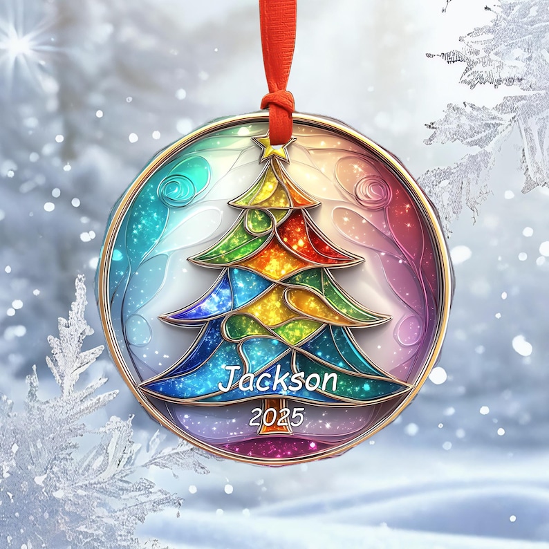 May include: A round Christmas ornament with a colorful stained-glass design of a Christmas tree. The ornament has a gold-colored border and a red ribbon for hanging. The name "Jackson" and the year "2025" are printed on the ornament.
