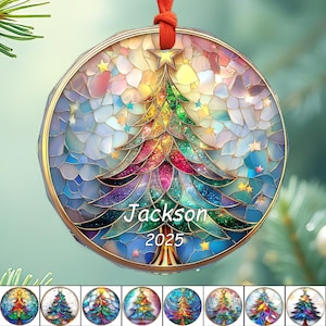 May include: A round Christmas ornament with a stained-glass design featuring a colorful Christmas tree and stars. The ornament has the name "Jackson" and the year "2025" printed on it. It is suspended by a red ribbon.