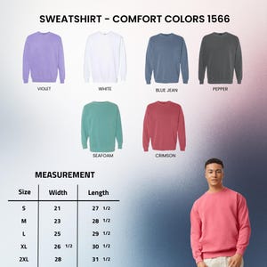 以下が含まれることがあります： 紫、白、ブルーデニム、ペッパー、シーフォーム、クリムゾンなど、さまざまな色のクルーネックのスウェットシャツのセレクション。画像には、サイズSから2XLまでの幅と長さのインチ単位の測定値を示すサイズチャートも表示されています。