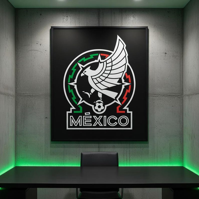 May include: A framed black poster featuring the Mexico national team emblem. The emblem includes a white eagle with outstretched wings, a soccer ball, and the word "M&Eacute;XICO" in white. The poster hangs on a gray concrete wall above a black desk.