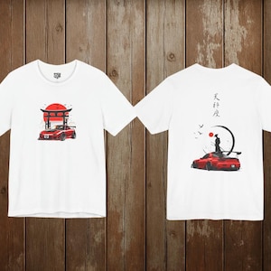 May include: White t-shirts with a Japanese-inspired design. One shirt features a red sports car in front of a torii gate and a rising sun. The other shirt has a red sports car with a samurai and Japanese text.