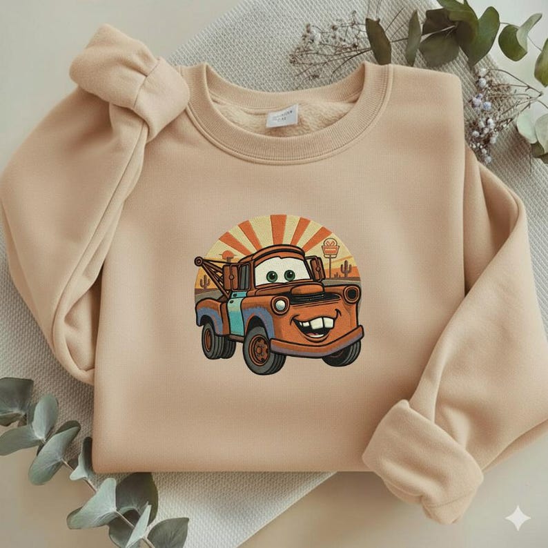 May include: A white ceramic mug with a black handle and the text "But First, Coffee" in a bold, black font. The mug is set against a blurred background, suggesting a cozy setting.