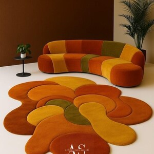 Puede incluir: Una moderna sala de estar con un sof&aacute; curvo y una alfombra a juego. El sof&aacute; y la alfombra tienen un dise&ntilde;o de patchwork en tonos naranja, amarillo y verde. La alfombra tiene una forma abstracta y org&aacute;nica. Tambi&eacute;n se ve una peque&ntilde;a mesa auxiliar con una planta.