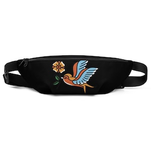 May include: Black fanny pack with a colorful bird graphic. The bird is orange, blue, and yellow, holding a green sprig and a yellow flower. The pack has a black adjustable strap and a zipper closure.