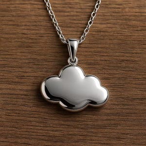 May include: A silver-colored cloud pendant necklace. The pendant is a three-dimensional cloud shape with a polished finish, suspended from a delicate chain. The necklace is displayed on a wooden surface.