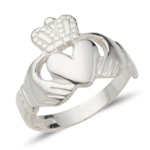Peut inclure: Une bague Claddagh en argent avec un cœur, deux mains et une couronne. La bague est un symbole irlandais traditionnel d'amour, de loyauté et d'amitié.