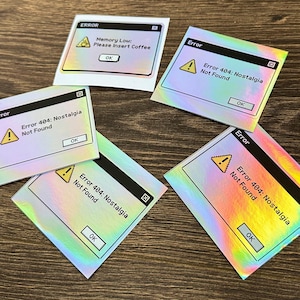 May include: A collection of holographic stickers with a computer error theme. The stickers display error messages like "Error 404: Nostalgia Not Found" and "Memory Low: Please Insert Coffee". Each sticker has an "OK" button.