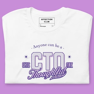 Könnte beinhalten: Weißes T-Shirt mit dem Text "Anyone can be a CTO" in Lila. Das Shirt zeigt auch die Worte "Chic One Thoughtful" in einer stilisierten Schriftart. Das Shirt hat ein Etikett mit der Aufschrift "Affection Club" und "Nicaragua".