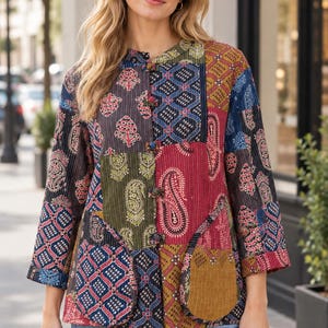 May include: A long-sleeved jacket featuring a patchwork design with various colourful patterns including paisley and floral motifs. The jacket has a mandarin collar, a front button closure with toggle-style fasteners, and two rounded front pockets.