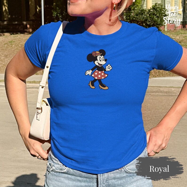 May include: A white ceramic mug with a black handle and the text "But First, Coffee" in a bold, black font. The mug is set against a blurred background, suggesting a cozy setting.