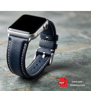 May include: A silver smartwatch with a navy blue leather band. The band features white stitching and a silver buckle. The watch is displayed on a textured gray surface. The text "HustebyTrade" is visible.