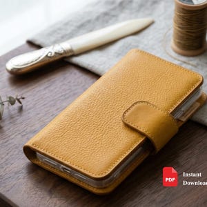 May include: A mustard yellow textured leather wallet-style phone case with a magnetic closure flap. The case features a pebbled grain finish and a clear plastic inner shell to hold a mobile device securely in place while closed.