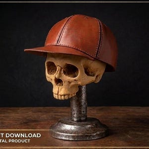 Pode incluir: Um boné de beisebol de couro castanho com costuras visíveis e uma aba estruturada. O boné é exibido num modelo de crânio humano montado num suporte de pedestal metálico. O design apresenta uma construção clássica de seis painéis.