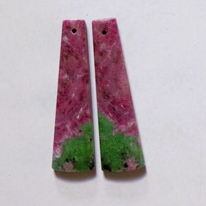 Può includere: Due ciondoli rettangolari in pietra preziosa. Ogni ciondolo è un mix di tonalità rosa e verde, con un foro praticato nella parte superiore per l'infilatura. Il rosa domina la parte superiore, passando al verde in basso. Ideale per la creazione di gioielli.