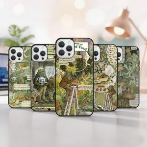 May include: A collection of five phone cases featuring illustrations of a frog in various scenes. The cases have a black border and a glossy finish. The artwork includes text and a whimsical, vintage aesthetic with green and brown tones.