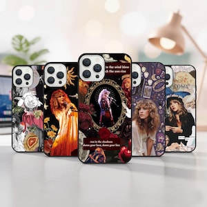 May include: A selection of phone cases with diverse designs. The cases showcase images of a singer, with text including "to the wind blow", "run in the shadows", and "I adore you". The cases have a black border and are displayed on a light surface.