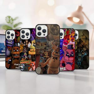 May include: A collection of phone cases featuring colorful designs with characters from the video game series Five Nights at Freddy's. The cases display various characters and the text "FIVE NII FREDI" and "Summer Of 72".