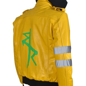 May include: Yellow bomber jacket with a black hood and cuffs. The back features a green graphic design. Reflective silver stripes are on the sleeves. The jacket is made of a smooth, shiny material.