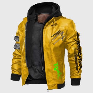 May include: A yellow leather jacket with a black hood and a black inner layer. The jacket features silver zippers, a black collar, and green and black text graphics on the sleeves and front. The jacket has a bomber style.