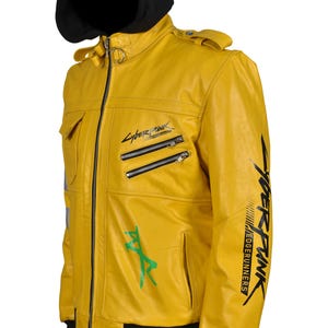 May include: A yellow leather jacket with a black hood. The jacket features multiple zippers, pockets, and green and black graphics. The text "Cyberpunk Edgerunners" is printed on the jacket.