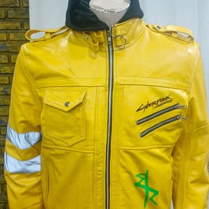 May include: A bright yellow leather jacket with a black hood and cuffs. The jacket features a zipper closure, two front pockets, and the word "Cyberpunk" printed on the front. Reflective stripes are on the sleeves.