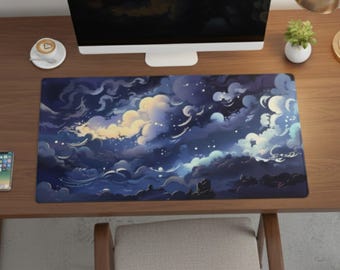 May include: A rectangular desk mat with a night sky design, featuring swirling clouds in blue, white, and yellow. The mat is on a wooden desk, with a computer monitor, a cup of coffee, and a small plant visible.