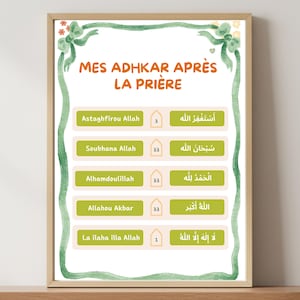 May include: A framed print with the text "MES ADHKAR APRÈS LA PRIÈRE" in orange. The print lists phrases in both English and Arabic, with corresponding numbers. The frame is a light brown color, and the border is green with floral accents.