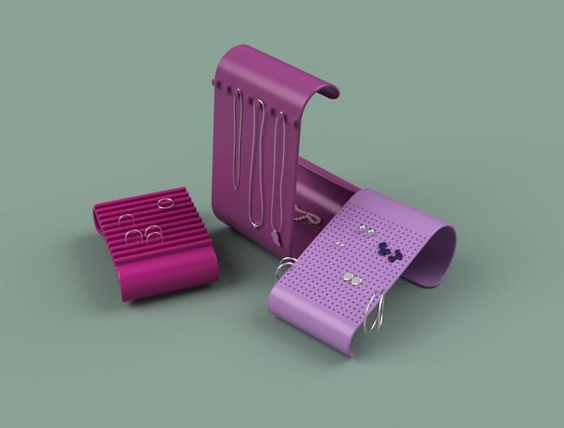 May include: A set of three magenta jewelry organizers. One is a rectangular earring holder, another is a necklace holder, and the third is a curved earring holder. The organizers are on a muted green background.