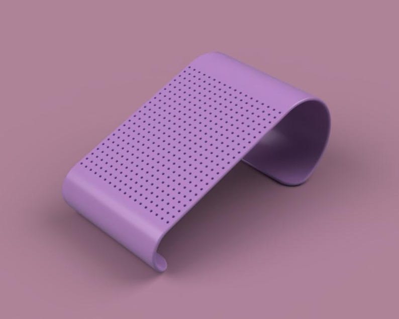 May include: A lavender-colored, curved stand with a perforated top surface. The stand has a smooth, minimalist design and is elevated on a matching lavender background. The curved shape and dotted pattern create a modern aesthetic.