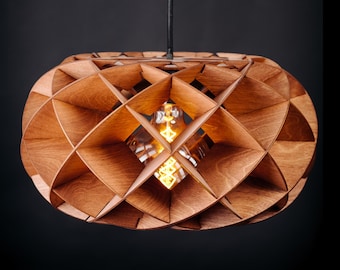 May include: A wooden pendant light fitting with a geometric design. The light is made of interlocking wooden pieces, creating a diamond pattern. The light bulb is visible inside the fitting, and it hangs from a black cord.