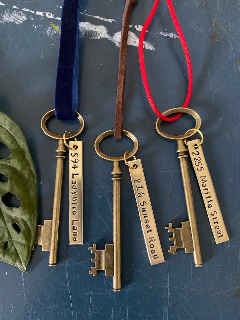 May include: Three antique-style skeleton keys with metal tags. The tags are engraved with the addresses "594 Ladybird Lane", "816 Sunset Road", and "2255 Marilla Street".