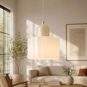 May include: A pendant light fixture featuring a cylindrical white glass shade suspended from a thin cord. The top of the shade is capped with a smooth, cream-colored dome-shaped component that connects to the cord with a small silver-toned metal fitting.