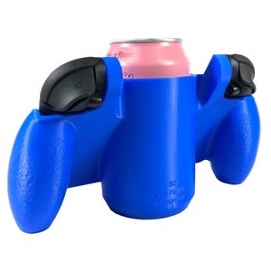Könnte beinhalten: Ein blauer Getränkehalter aus Kunststoff in Form eines Joy-Con-Controllers mit einer rosa Dose. Er hat schwarze Knöpfe und den Text "SZ Can Hold Joycon Grip".