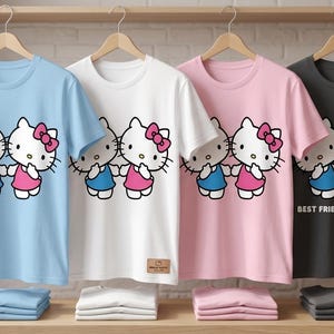 May include: Four short-sleeved t-shirts in light blue, white, pink, and charcoal gray, each featuring a graphic of two Hello Kitty characters holding hands. The charcoal shirt has the text "BEST FRIENDS FOREVER".